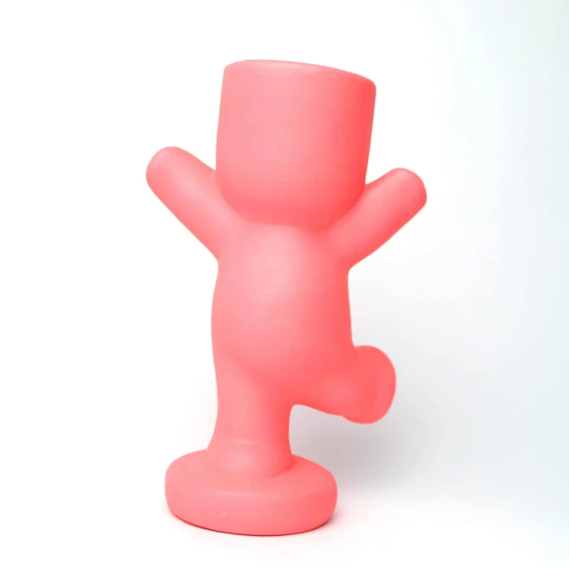a pink plastic sculpture stands in front of a white backdrop