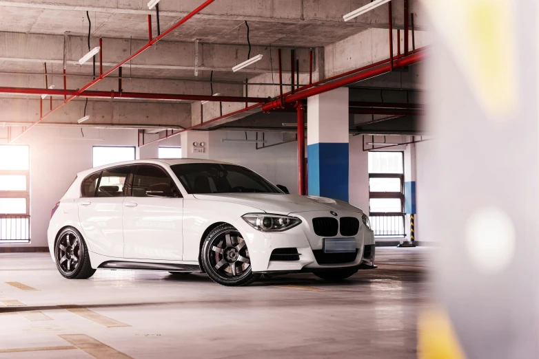 a white car is parked in a parking garage