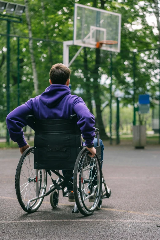 a  is in a wheelchair at a basketball hoop