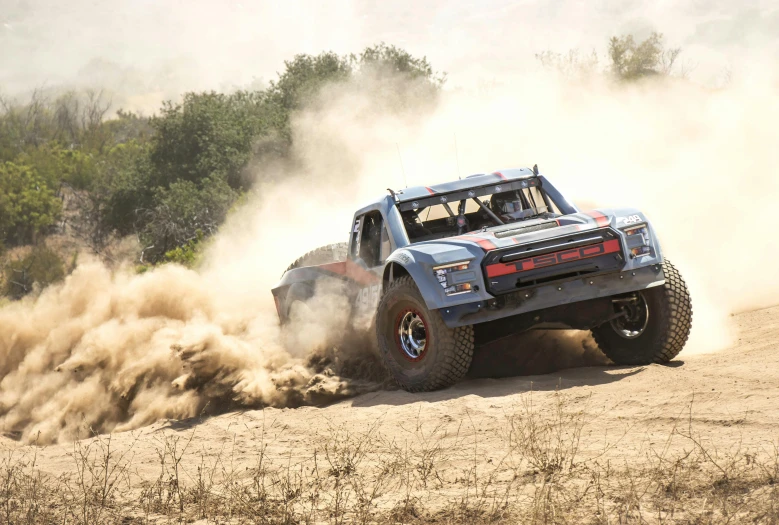 a blue truck that is sitting in the dirt