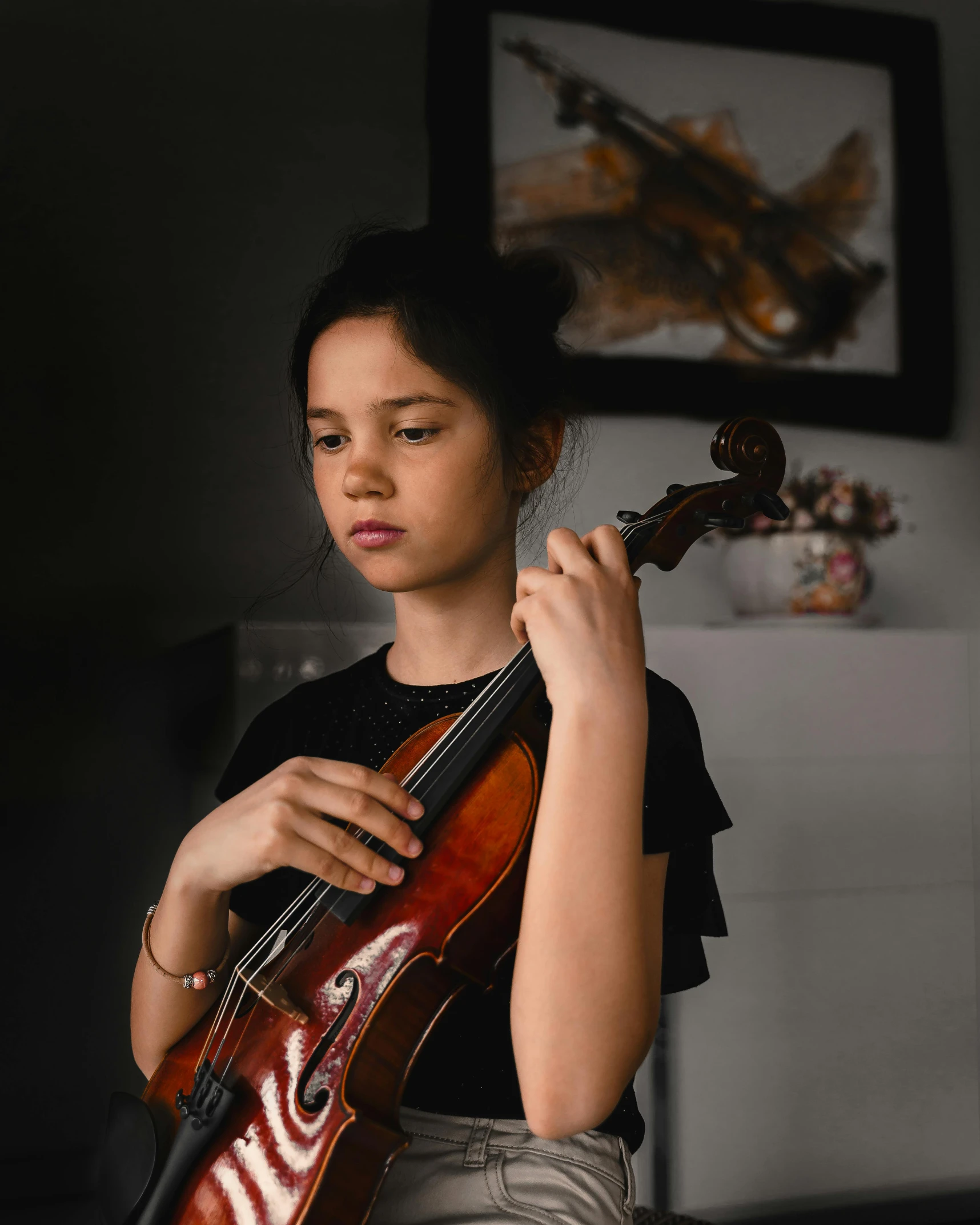 a woman playing a violin while wearing a black top