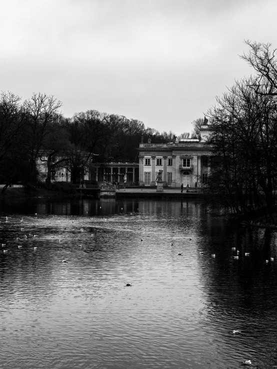 an old mansion with a pond in front of it