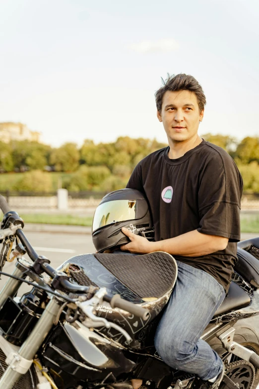 a man sitting on a motorbike with his helmet over his face