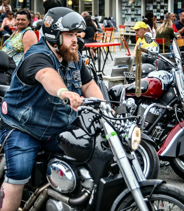 some people at outdoor tables riding on some motorcycles