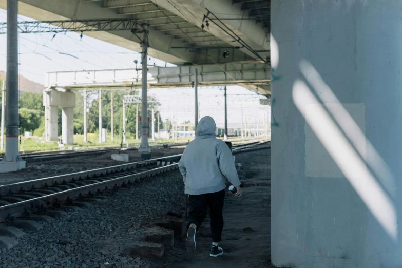 a man standing next to an old railroad track