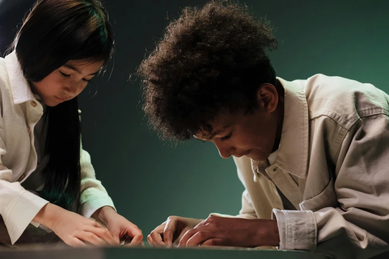 two people are playing with a piece of paper