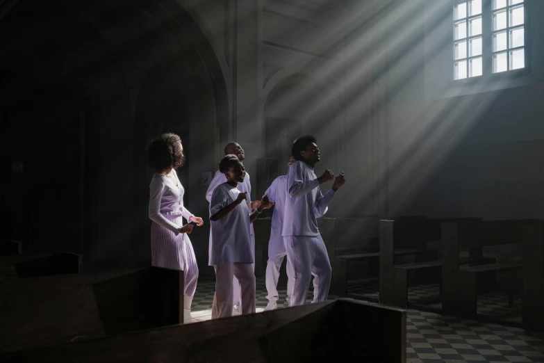 a group of people standing in the sunlight with shadows