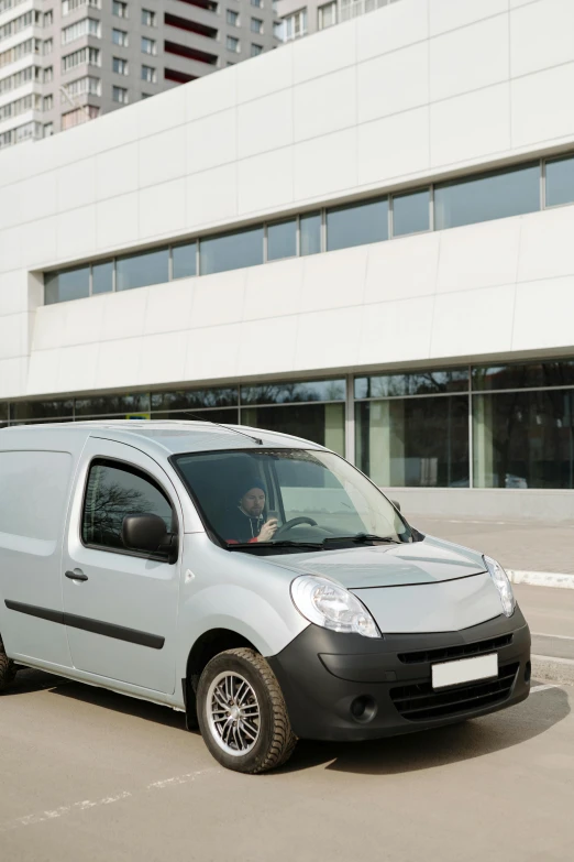 a small white van parked in front of a building