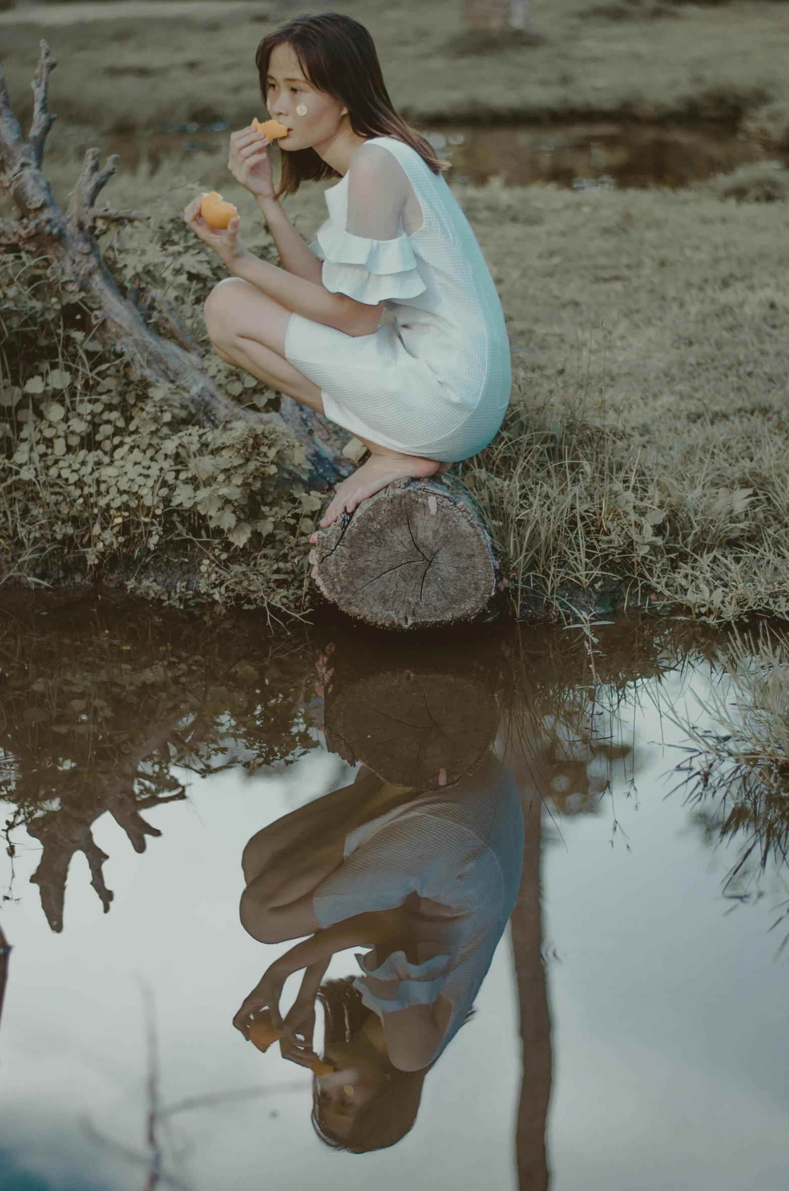 a beautiful young lady eating soing by the river