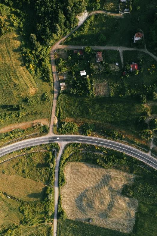 an aerial s of a highway surrounded by fields