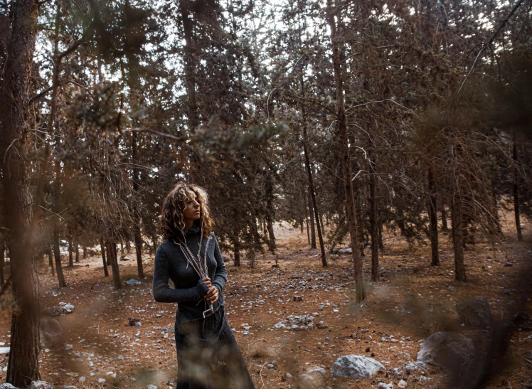 a man stands in a pine forest in the distance