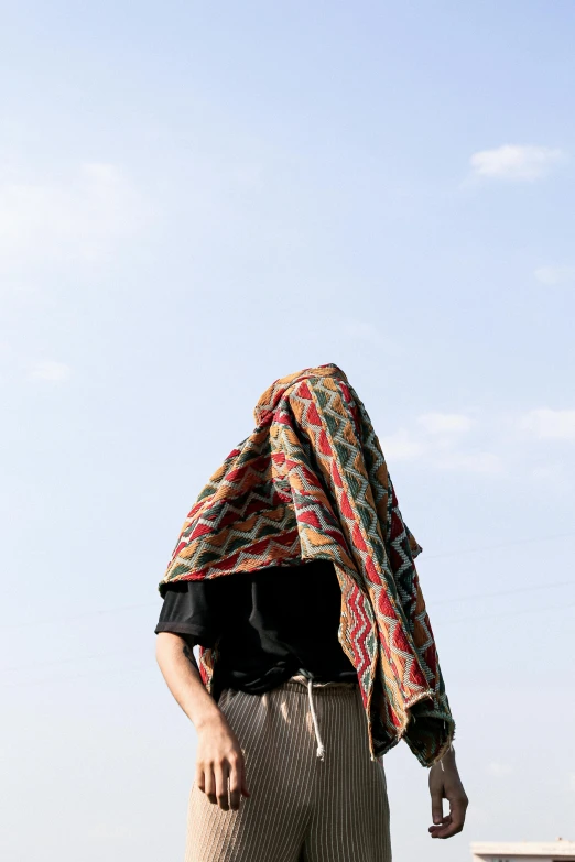 a man in patterned clothing with a skateboard under his arm