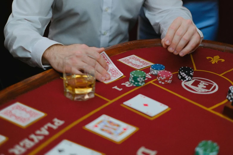 a man at a table holding two dice with several card on the table