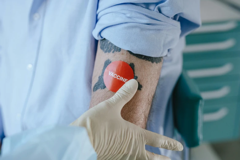 an arm wearing gloves holding up a  type tattoo