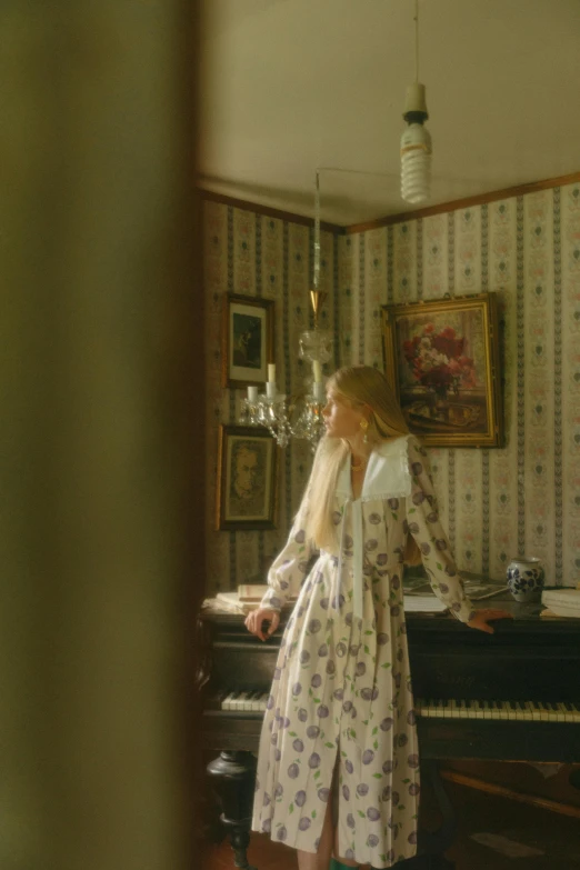 a young woman sitting at a piano in her home