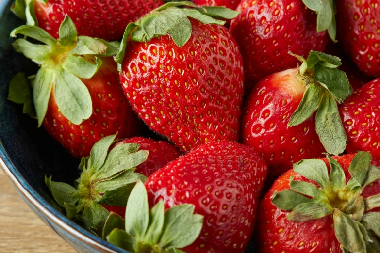 a bowl full of strawberries on the table