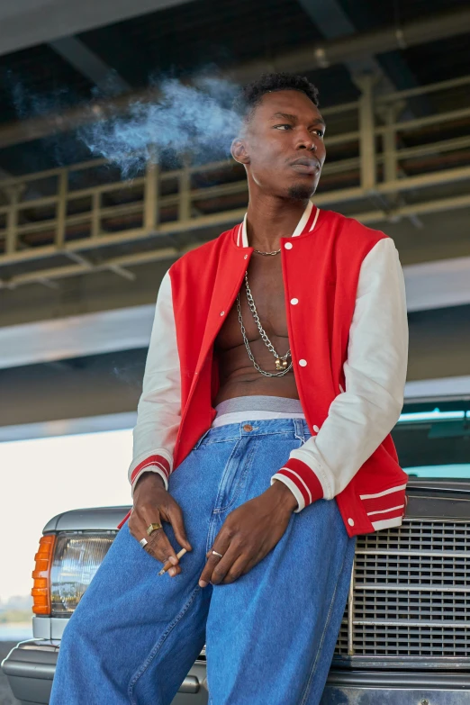 a man sits on the hood of his truck