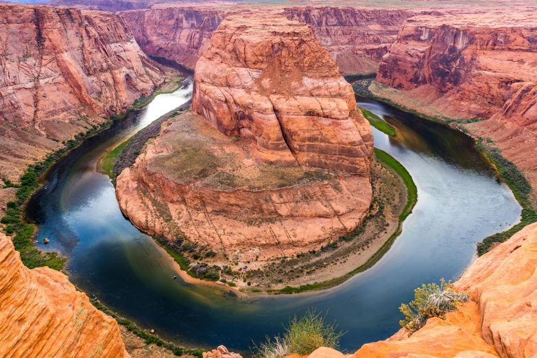 a canyon in the desert with a river and a bridge