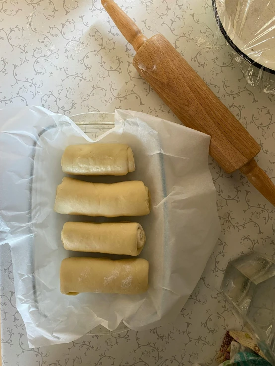 a bunch of dough next to a rolling pin