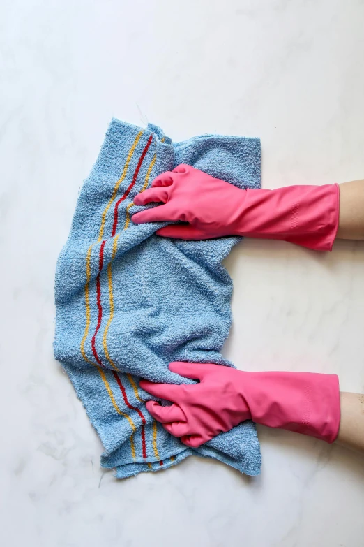 a pair of pink gloves on top of two blue towels