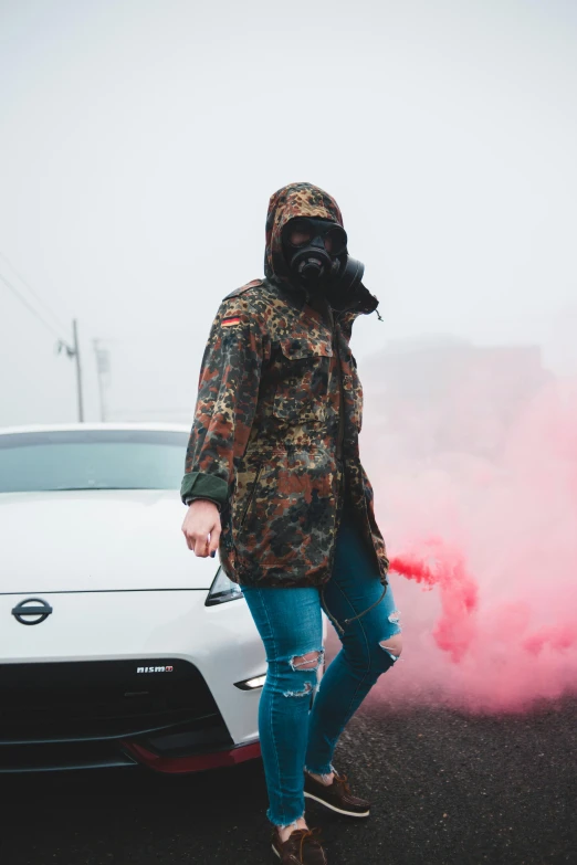 a person wearing a gas mask and standing next to a white car