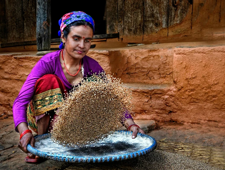 a woman with a woven headpiece working on a tray