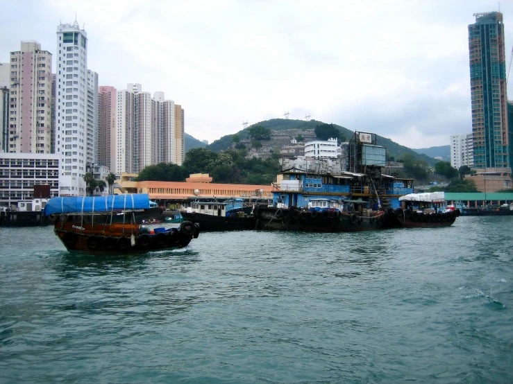 two boats traveling across a harbor with a city in the background