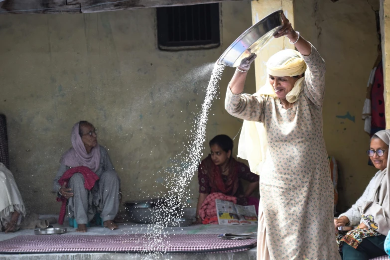 people sitting around a table pouring water on top of each other