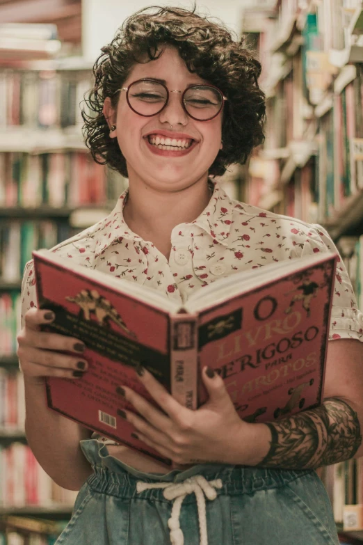 young female reading a book in front of a bookshelf