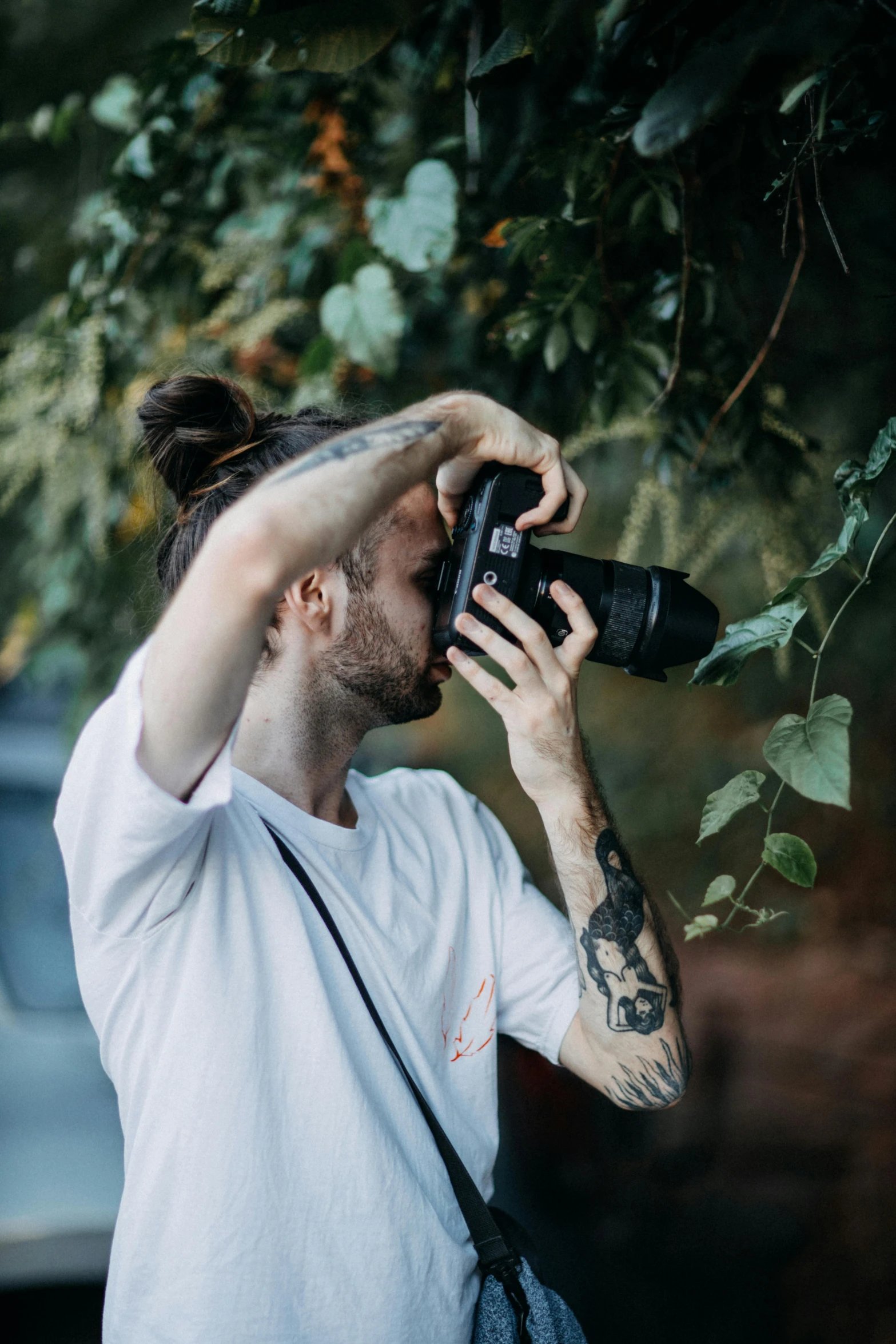 a man with tattoos is looking through a camera