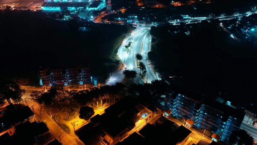 a city at night with lights on and a road going by