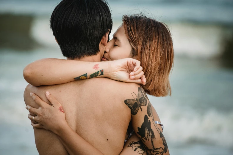 couple emcing each other during poshoot at the beach