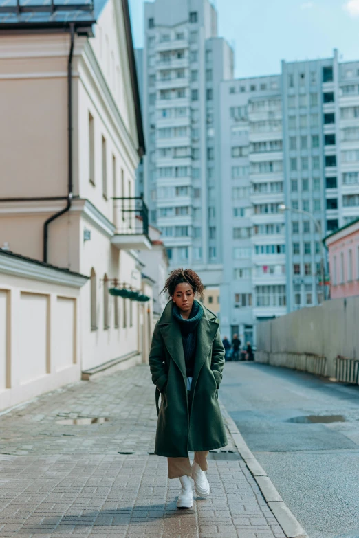 a woman is walking down the street next to buildings