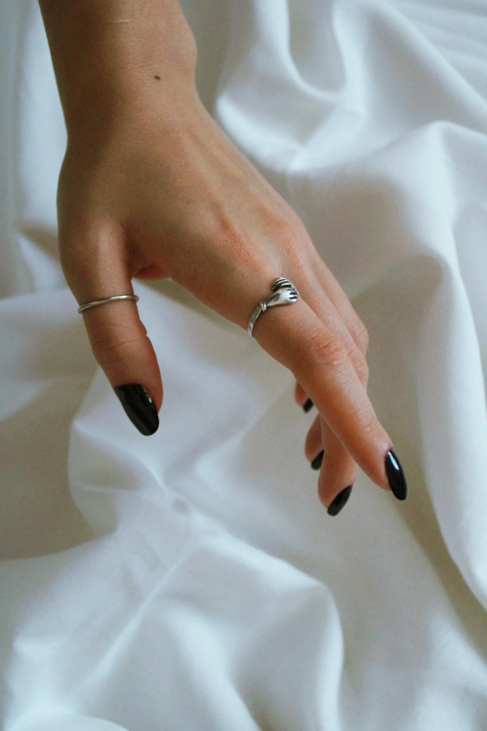 a woman's hand that is on a white sheet