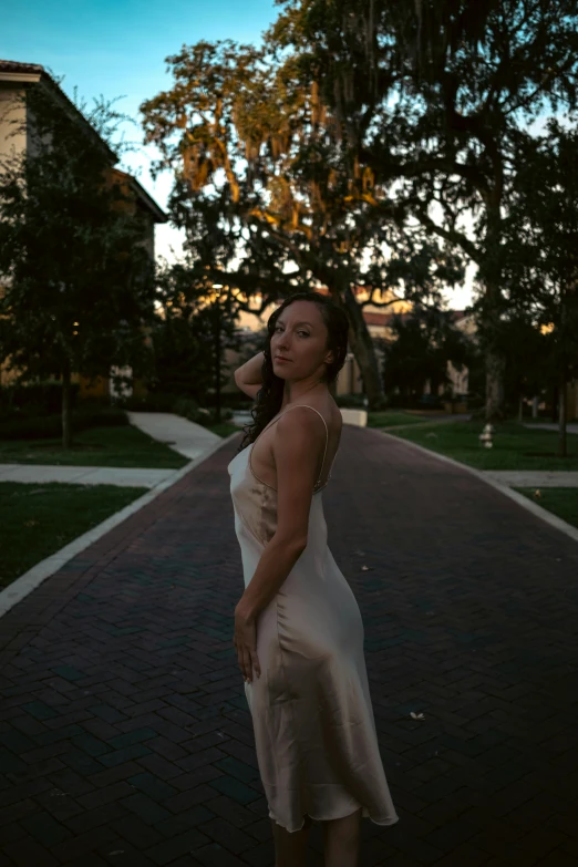 a woman is in the middle of a road, with her hair in her wind