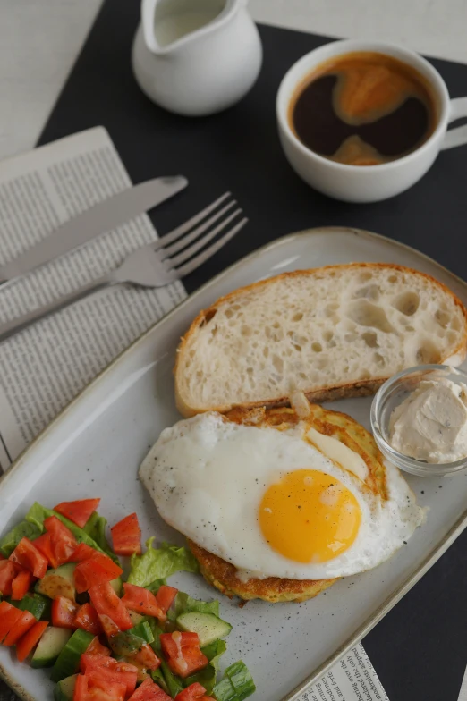 an egg on toast, tomato salad and coffee