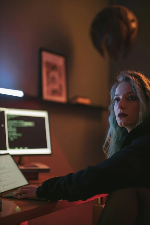 a woman sitting at a desk in front of a computer