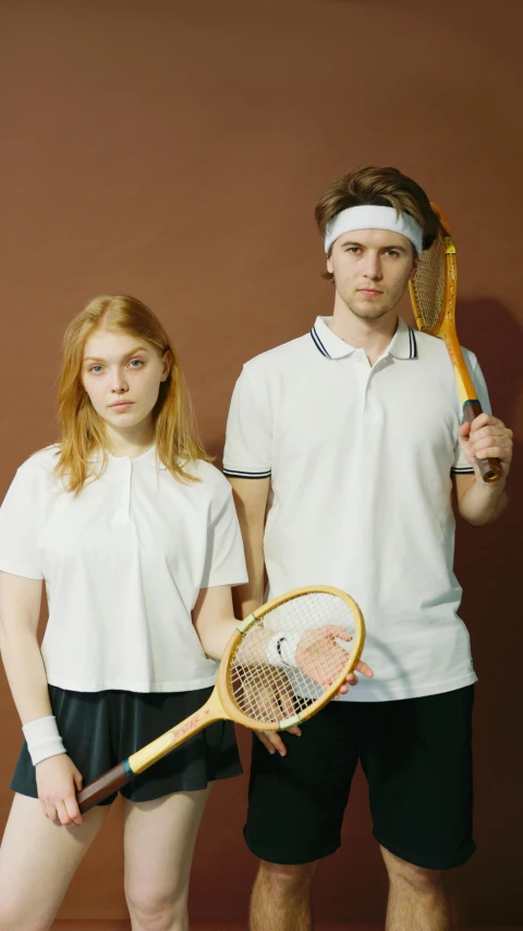 a man and a woman with tennis rackets posing for a po