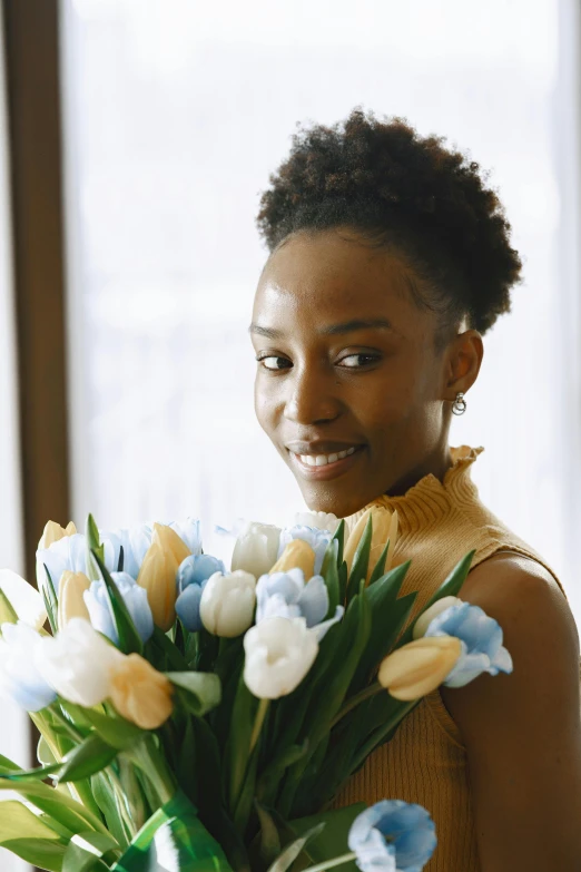 a woman holds a vase with flowers in it