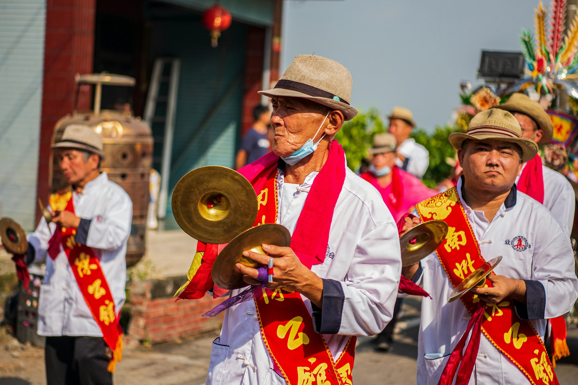 men in ethnic costumes hold signs and play trombones