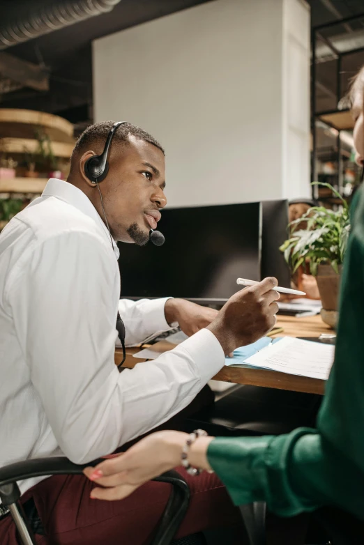 a man wearing ear phones is working at a desk