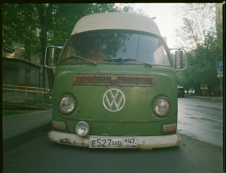 a large green van sitting on top of a parking lot