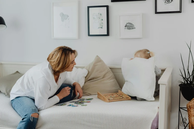 a woman sitting on the bed reading a book