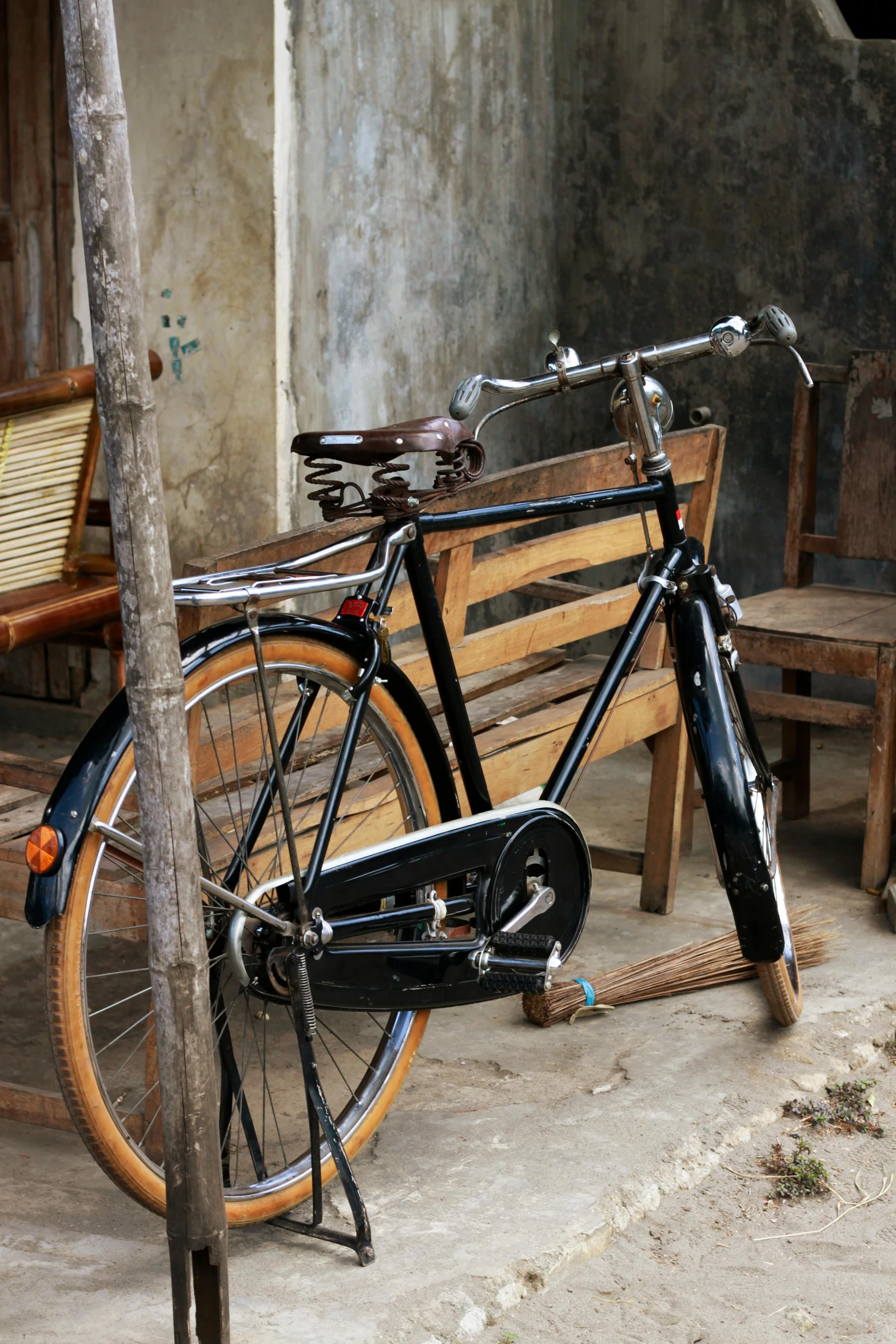 an old bicycle sitting next to a wooden bench