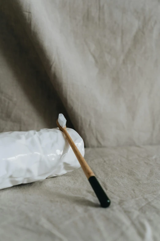 toothbrush with white bristles resting on white towel