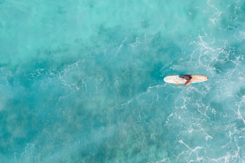 a person laying on top of a surfboard in the ocean