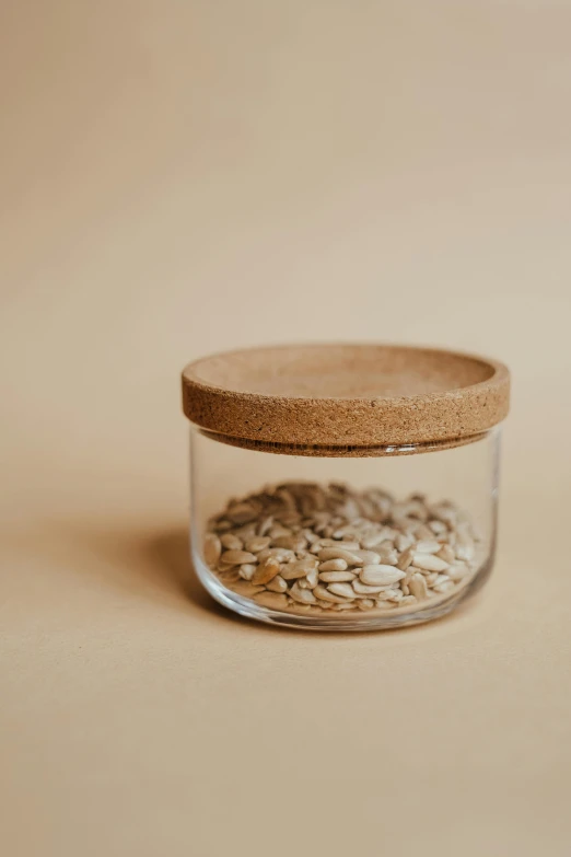 a glass jar with wood lid is filled with wheat