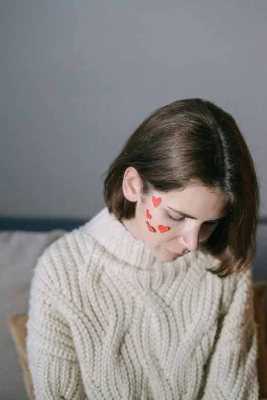 a woman with face painted red and a white sweater on