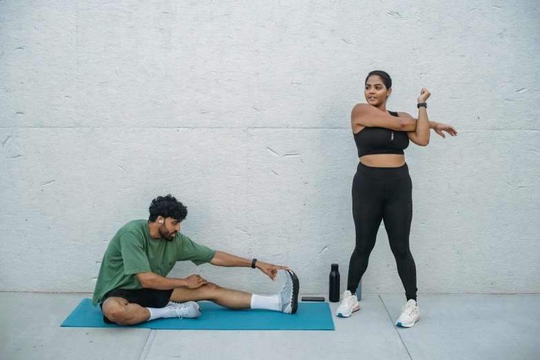 a woman doing exercises with someone stretching their legs