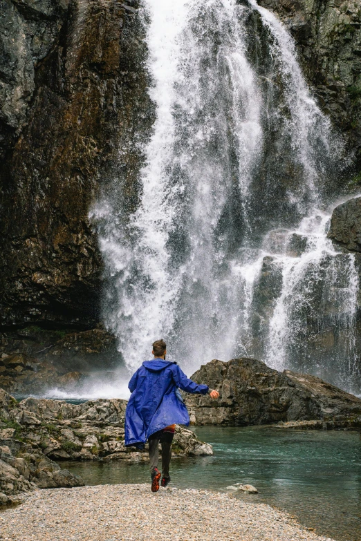 a person standing in front of a large waterfall